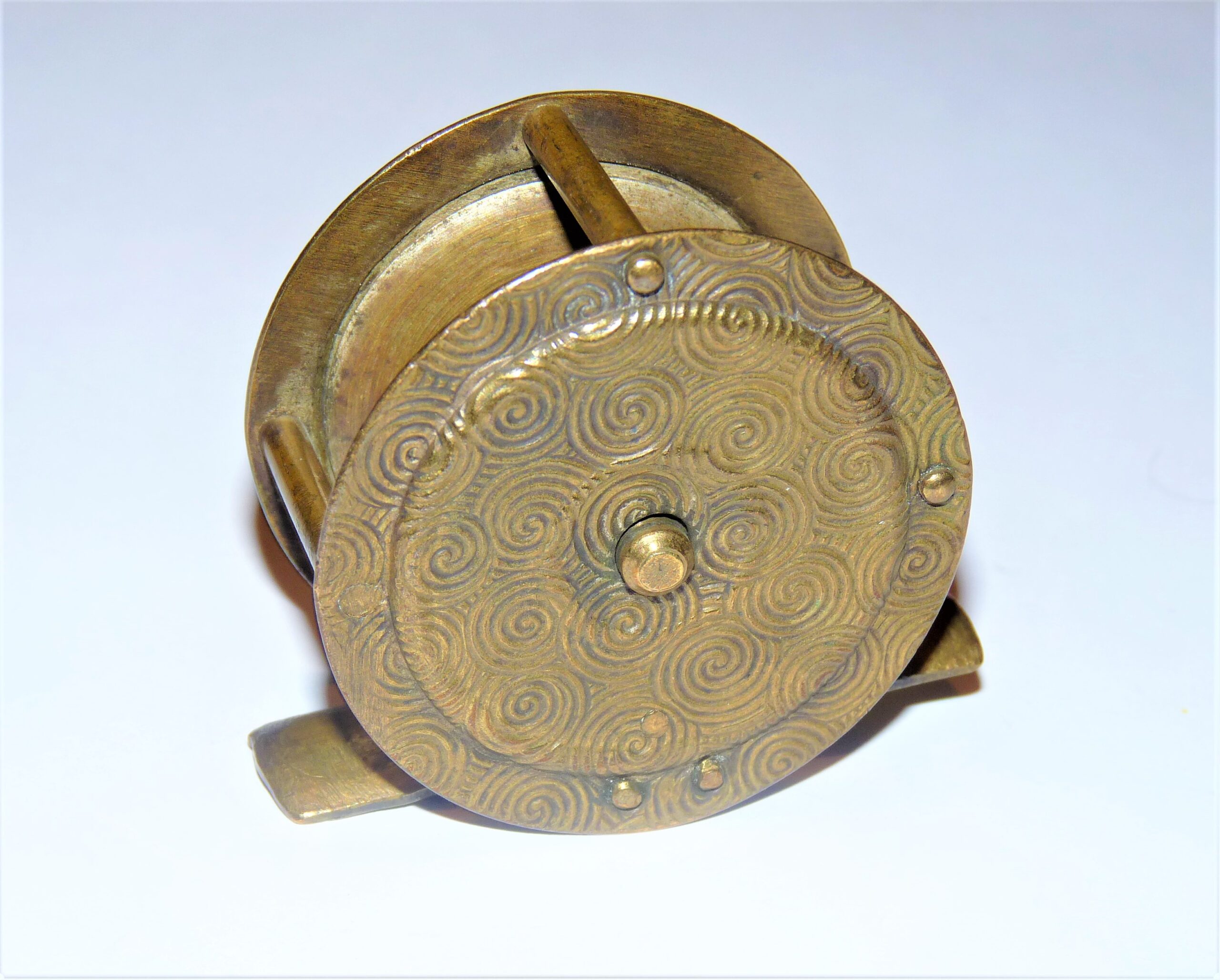 Brass 2" vintage fishing reel with decorative flower swirl to front & back plates to display - Image 2