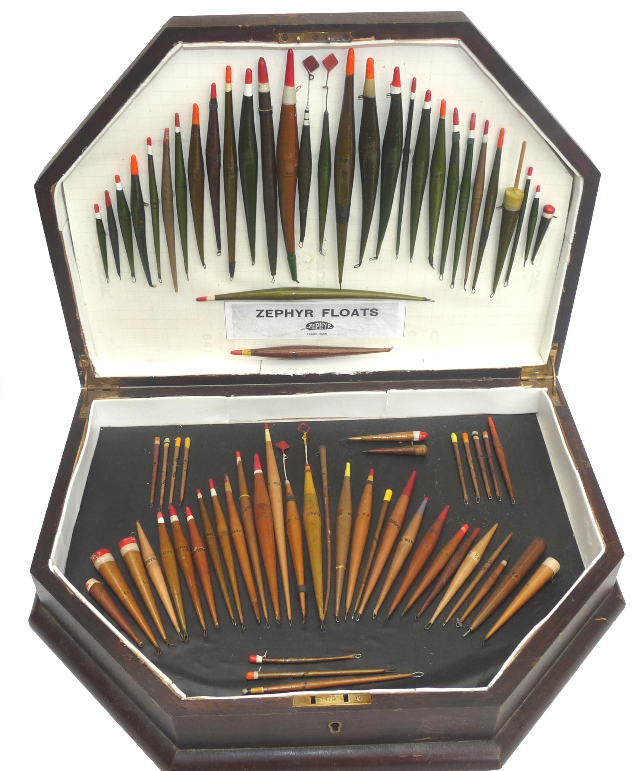 Collection of 75 Zephyr Patent rolled paper floats in wooden display case